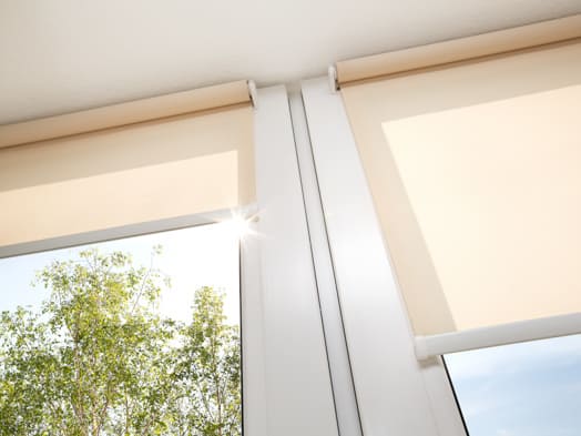 Window with sand coloured roll sun blinds